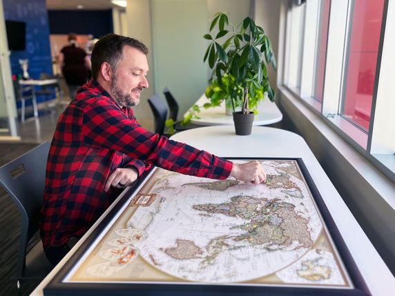 Employee placing a pin on a world map
