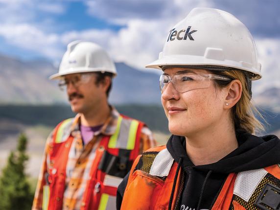 Two employees participating in an Indigenous awareness event outdoors.